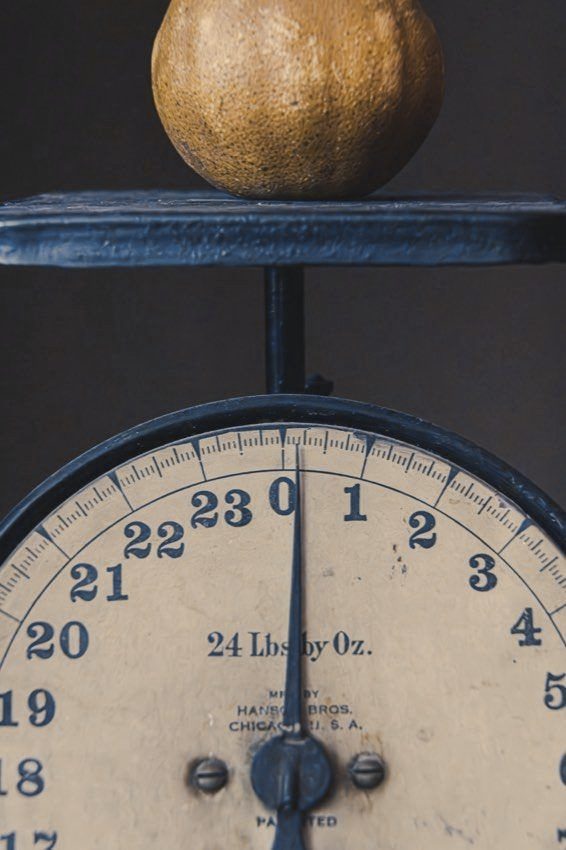 An old kitchen scale with a piece of fruit on top