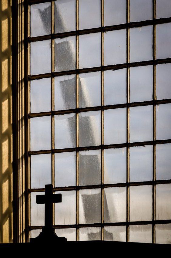 A tall grid of window panes, a cross at the bottom